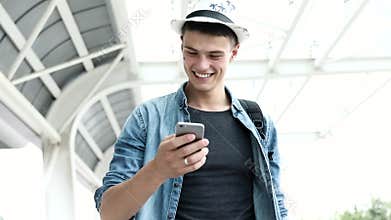 Traveling. Smiling Man With Baggage Using Mobile Phone