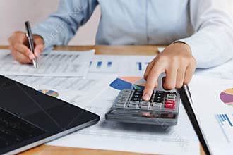 accountant using calculator with pen on desk for calculate finance dat