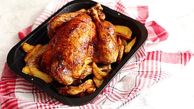 Roasted chicken or turkey with potatoes in black steel mold