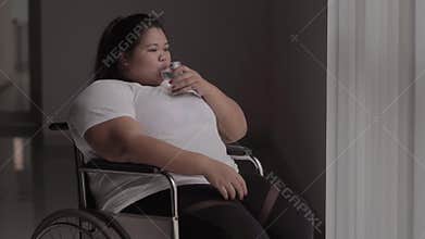 Disable overweight woman drinking drug