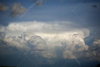 Cumulus storm clouds in summer against blue sky