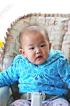 A little baby sets on high chair