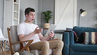 Shocked man in awe while using tablet