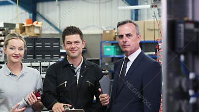 Portrait of business owner in factory with engineering team