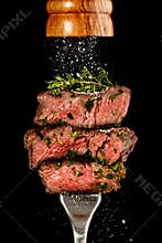 Sliced beef steak from grill on a fork