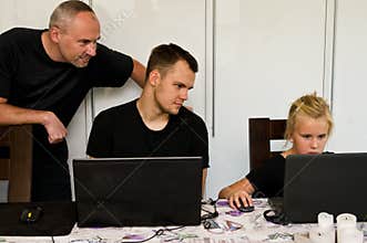 Father, son and duaghter together with laptop computers