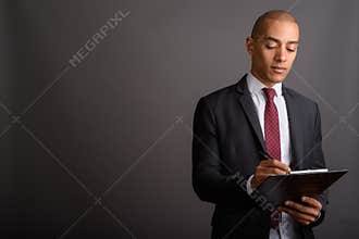 Handsome bald businessman holding clipboard and planning