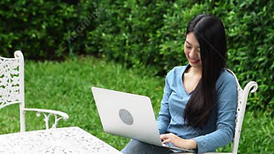 Portrait beautiful asian young woman sitting in the park using laptop computer at home for leisure and relax