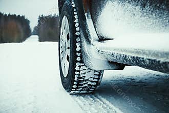 Car tires covered with snow on winter road.