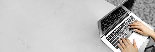 Website heading and banner of laptop with typing female hands, copy space in grey color.