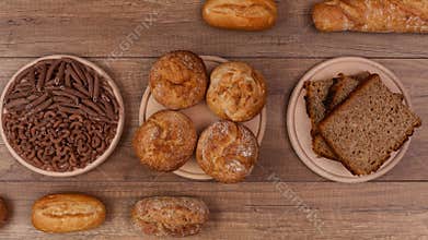 Bakery products and pasta made of wholemeal on rotating plates - top view