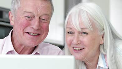 Senior Couple Using Laptop To Connect With Family