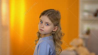 Lovely sad little girl turning and looking to camera, family problems, adoption