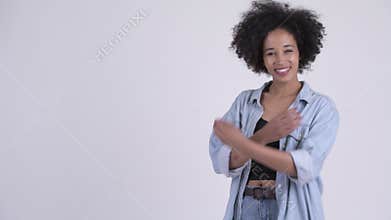 Profile view of happy young beautiful African woman with arms crossed
