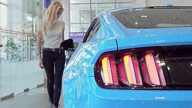 Selective focus on car lights, woman choosing automobile to buy on background