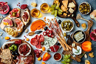 Appetizers table with antipasti snacks and wine in glasses. Bruschetta or authentic traditional spanish tapas set, cheese and meat