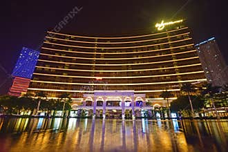 Wynn Macau at night with many colourful lights decorating the surrounding & beautiful water reflection