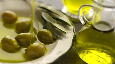 Organic olive oil pouring to olives