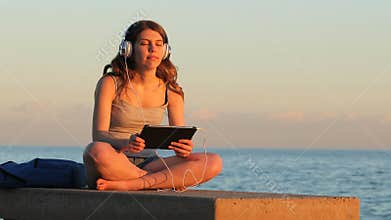Teen relaxing listening chill out music at sunset
