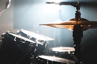 Close-up Drum set in a dark room against the backdrop of the spotlight. Atmospheric background symbol of playing rock or
