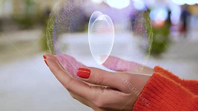 Female hands holding a conceptual hologram with white heart