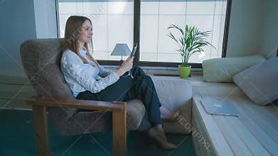 Attractive woman has video call on the touch tablet.