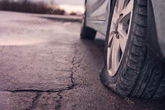Flat tyre on road. Car tire leak because of nail pounding. Toned