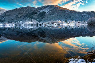 Winter Landscape with Snowy Mountains, Colorful Clouds, Lake Reflection at Sunset
