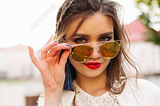 Pretty girl in sunglasses looking at camera.