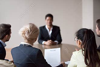 Rear view of hr listening to applicant at job interview