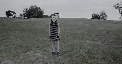 Young girl in white mask turns and then tilts her head to the side creepily