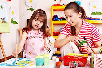 Child in preschool with teacher draw.