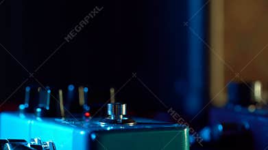 Close up of guitar player foot pressing pedal. Musician uses music effect loop machine. Man in trendy sneakers, his foot