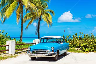 American blue 1955 classic car with a white roof parked direct on the beach in Varadero Cuba