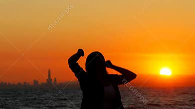 Excited woman jumping at sunset celebrating success