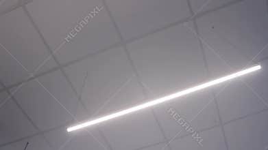 Fluorescent neon light tube on strings, slider shot