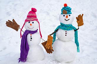 A loving couple of snowmen. Christmas background with couple of snowman. Snowman couple outdoor. Cute snow man in hat