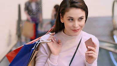 Woman with credit card and shopping bags during big shopping