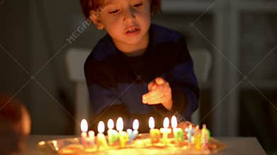 Happy Kid Blowing Candles at his Anniversary