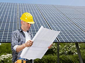 Electrician standing near solar panels
