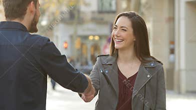 Woman and man handshaking in the street