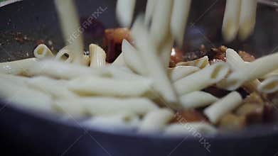 Food preparation: macaroni fall on steamed tomatoes, onions and eggplants