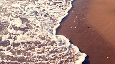Sea waves on the beach at sunset, summertime seascape background