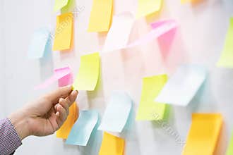 hand people business man  notes pad in the wall at meeting room. Sticky post it note paper reminder schedule board.