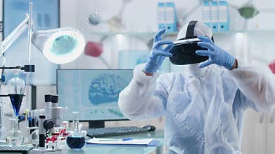Scientist wearing VR headset in professional laboratory is working in virtual reality