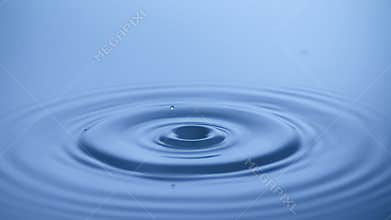 Slow motion Water drop splash into calm water - shot with ultra high speed camera