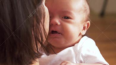 Mother holding and soothing crying baby girl
