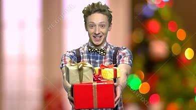 Funny boy giving you Christmas gift boxes.