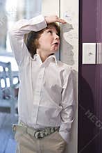 Young child measuring height on growth chart
