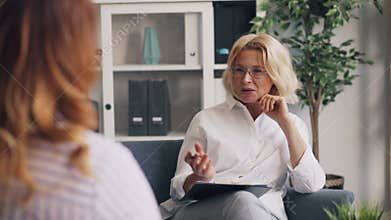 Positive psychoanalyst smiling laughing during conversation with female patient